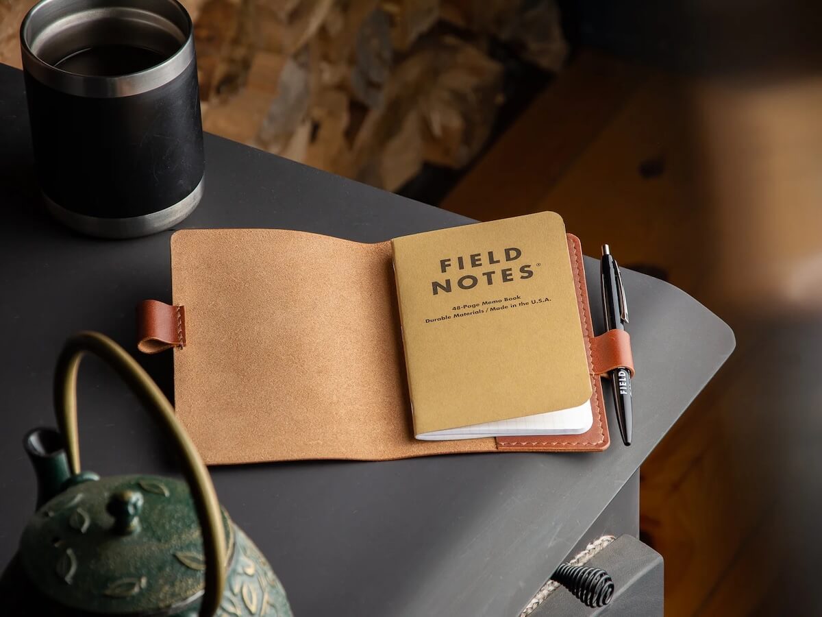 Field Notes notebook laying out with pen and leather wrap